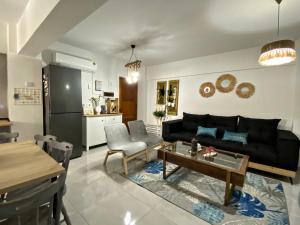 a living room with a black couch and a table at Peaceful 2 bedroom Flat in İncirli
