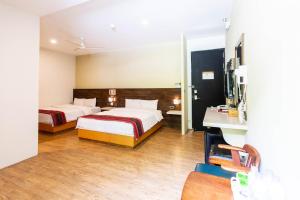 玉里鎮にあるAn Tong Hot Spring Hotelのベッド2台とデスクが備わるホテルルームです。