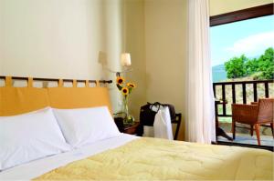 1 dormitorio con 1 cama y vistas a un balcón en Kaimak Mountain Lodge en Panayítsa