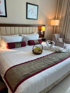 a hotel room with a large bed with a basket on it at Treppan Hotel & Suites By Fakhruddin in Dubai