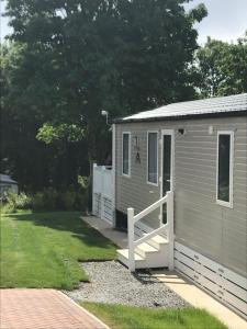 einen kleinen grauen Schuppen mit einer Veranda und einem Hof in der Unterkunft Luxury Holiday Home Sleeps 6 Pet Friendly in St Austell