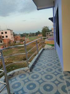 a balcony of a house with a tile floor at Kavre Guest House in Lumbini