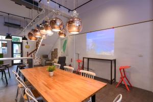 a dining room with a wooden table and chairs at On My Way Hualien Hostel in Hualien City