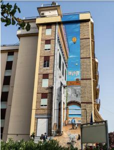 un edificio con un gran mural en su lateral en La Locomotiva, en Chiaravalle