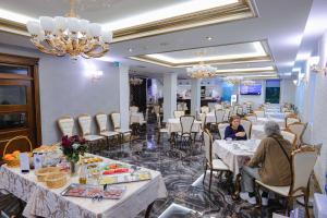 a group of people sitting at tables in a restaurant at Hotel Boka in Tirana