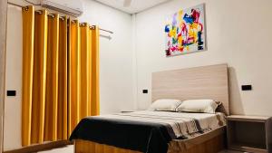 a bedroom with yellow curtains and a bed at Muladdu Inn in Feydhoo