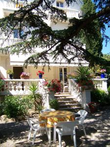 a table and chairs in front of a house at Le Thimothée : Hôtel & Studios in Saint-Raphaël