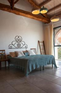 um quarto com uma cama com um cobertor azul em B&B The Wine Room - Az. Agr. Matunei em Cardona