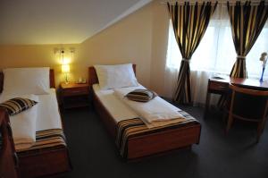Un pat sau paturi într-o cameră la Hotel Galerija