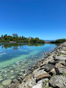 a river with rocks and a blue sky at Muladdu Inn in Feydhoo