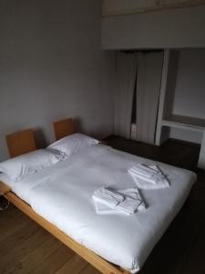 Una cama con sábanas blancas y toallas. en Agriturismo Pian Di Meta Vecchia, en Castiglione dʼOrcia