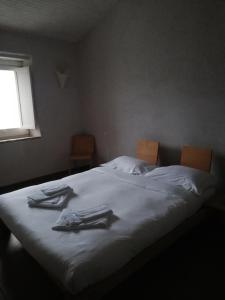 um quarto com uma cama branca com roupas em Agriturismo Pian Di Meta Vecchia em Castiglione dʼOrcia