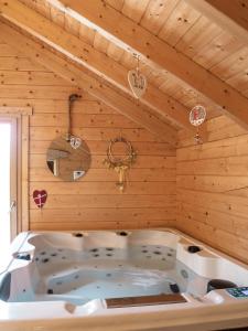 a bath tub in a room with wooden walls at Le Chalet au vieux vignoble avec espace Sauna et Jacuzzi in Bouxwiller