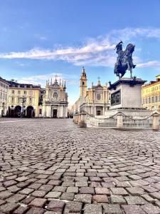 a square with a statue in front of a building at San Carlo Suite Torino in Turin