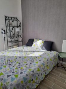 Una cama con edredón en un dormitorio en le ch'ti 4 saisons Maison de vacances avec parking et jardin, en Saint-Omer