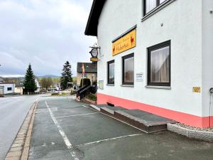 un edificio con un reloj al lado de una calle en Pension Hubertus, en Bad Steben