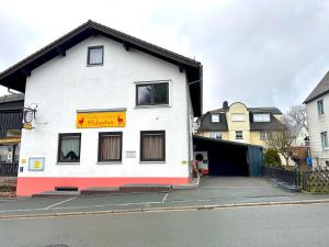 um edifício branco com um sinal na lateral em Pension Hubertus em Bad Steben