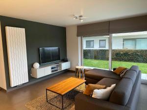 a living room with a couch and a tv at Villa Moya in Nieuwpoort