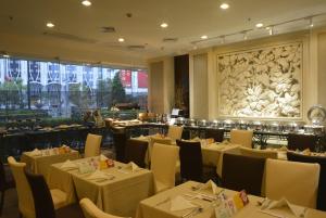 um restaurante com mesas e cadeiras e uma grande janela em Rosedale Hotel & Suites Guangzhou - Free Shuttle Bus to Canton Fair em Guangzhou