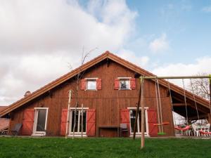 a large wooden house with a gambrel at Le Chalet au vieux vignoble avec espace Sauna et Jacuzzi in Bouxwiller