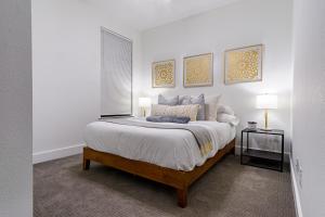 a white bedroom with a large bed and two lamps at Beautiful Contemporary 4BR near Downtown Dallas in Dallas