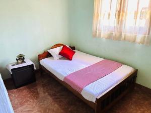 Un dormitorio con una cama con almohadas rojas. en Lakbima Holiday Lodge, en Devinuwara