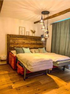 a bedroom with a large bed with a wooden headboard at Heimelige Ferienwohnung mit Sicht in die Bergwelt in Bivio