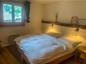 a bedroom with a large white bed with a window at Heimelige Ferienwohnung mit Sicht in die Bergwelt in Bivio