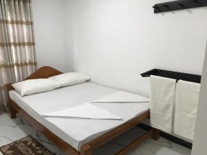 uma cama com duas almofadas num quarto em aji fruit farm em Embilipitiya
