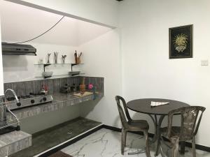 a kitchen with a table and chairs and a sink at aji fruit farm in Embilipitiya