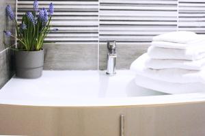 un lavabo con toallas y un jarrón de flores en Appartamento in via San Gallo, en Florencia