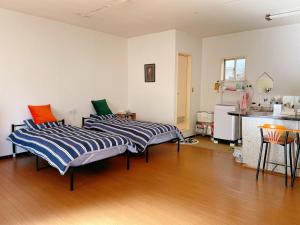 甲府市にある富竹民泊のキッチン付きの客室で、ベッド2台が備わります。