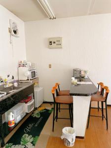 a kitchen with a table and chairs in a kitchen at 富竹民泊 in Kofu