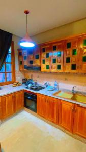 eine Küche mit Holzschränken und blauem Licht in der Unterkunft Villa Marrakech in Marrakesch