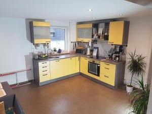 una cocina con armarios amarillos y electrodomésticos amarillos en Zimmer 1 nahe Thoraxklinik - Bad und Küche geteilt, en Heidelberg
