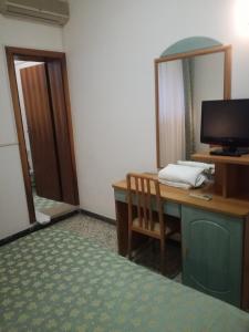 een kamer met een bureau, een computer en een spiegel bij Hotel Dall'Ara in Villa Marina