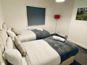 a hotel room with two beds and a window at Kingsway Lounge - Accomodation for Nuneaton Contractors & Industrial estate - Free Parking & WIFI Sleeps up to 7 people in Nuneaton