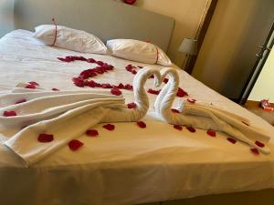two swans laying on a bed covered in hearts at Guesthouse Vakantie Logies Hollywood in Bruges