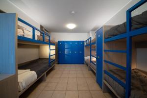 ロヴェレートにあるOstello Città di Roveretoの二段ベッドと青いドアが備わる客室です。