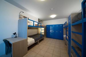 Zimmer mit Etagenbetten und einem Schreibtisch. in der Unterkunft Ostello Città di Rovereto in Rovereto
