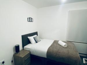 Habitación pequeña con cama y mesita de noche en Kingsway Lounge - Accomodation for Nuneaton Contractors & Industrial estate - Free Parking & WIFI Sleeps up to 7 people, en Nuneaton