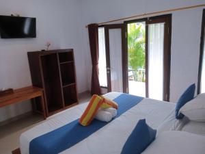 a bedroom with a bed and a tv and a bed sidx sidx sidx at Japa Bungalow in Nusa Penida