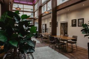 a dining room with tables and chairs and a plant at The Woolacombe Bay Hotel in Woolacombe