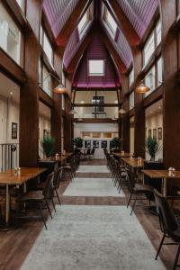 a dining room with tables and chairs and windows at The Woolacombe Bay Hotel in Woolacombe