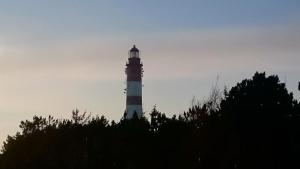 a lighthouse sitting on top of a hill at Ahoi in Norddorf