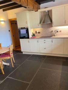 a kitchen with white cabinets and a table and a sink at Dunes View, Cottage1, Dunnetbay accommodation in Castletown
