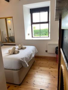 a bedroom with a bed with a mirror and a window at Dunes View, Cottage1, Dunnetbay accommodation in Castletown