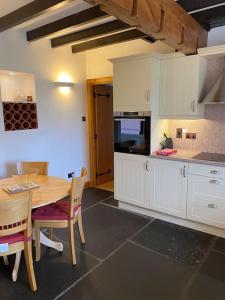 a kitchen with a table and a table and chairs at Dunes View, Cottage1, Dunnetbay accommodation in Castletown