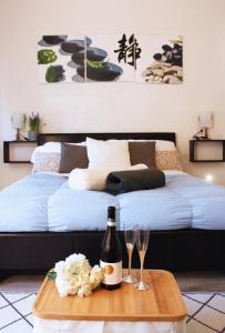 Una cama con una botella de vino y dos copas en una mesa. en Appartamento in via San Gallo, en Florencia