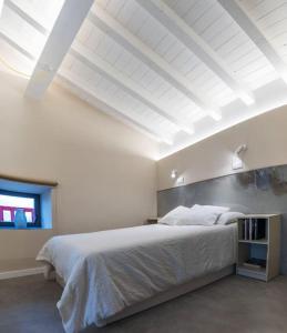 een witte slaapkamer met een groot bed en een raam bij Apartamentos en Baztan HIRU KABI, HIGA 